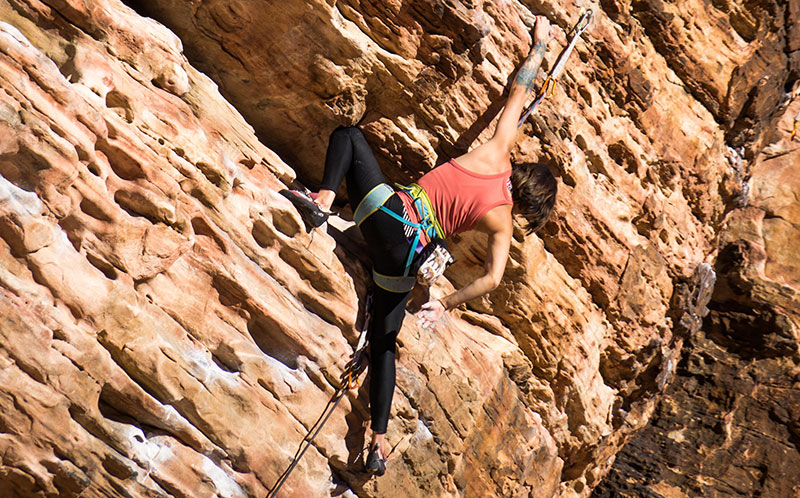 Person facing struggle rock climbing up a face of a mountain